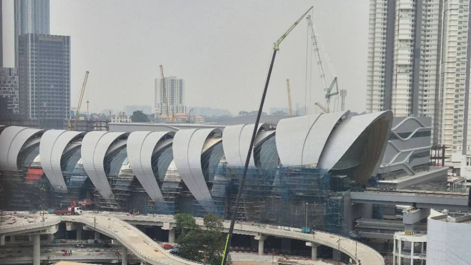 Bukit Chagar RTS Link station area with station roofs, cranes and construction structures visible.